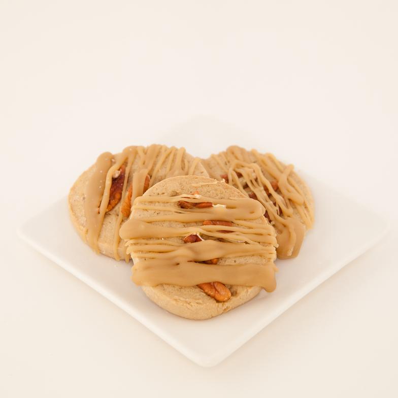 Maple cookie topped with pecans and drizzled with a brown sugar glaze. A favorite guy cookie!